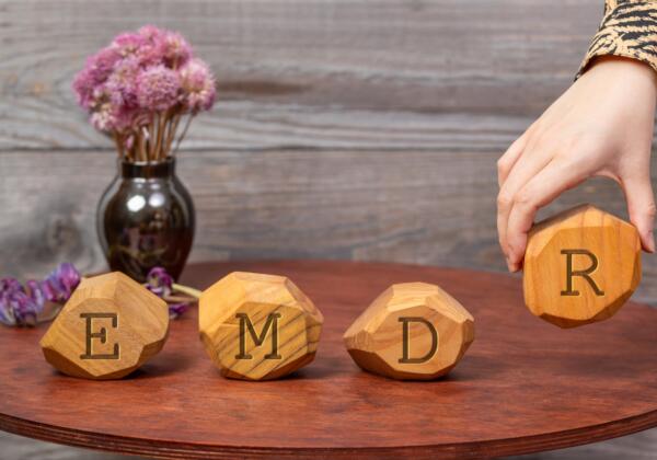 Letters,emdr,written,on,irregular,wooden,blocks.,a,woman's,hand